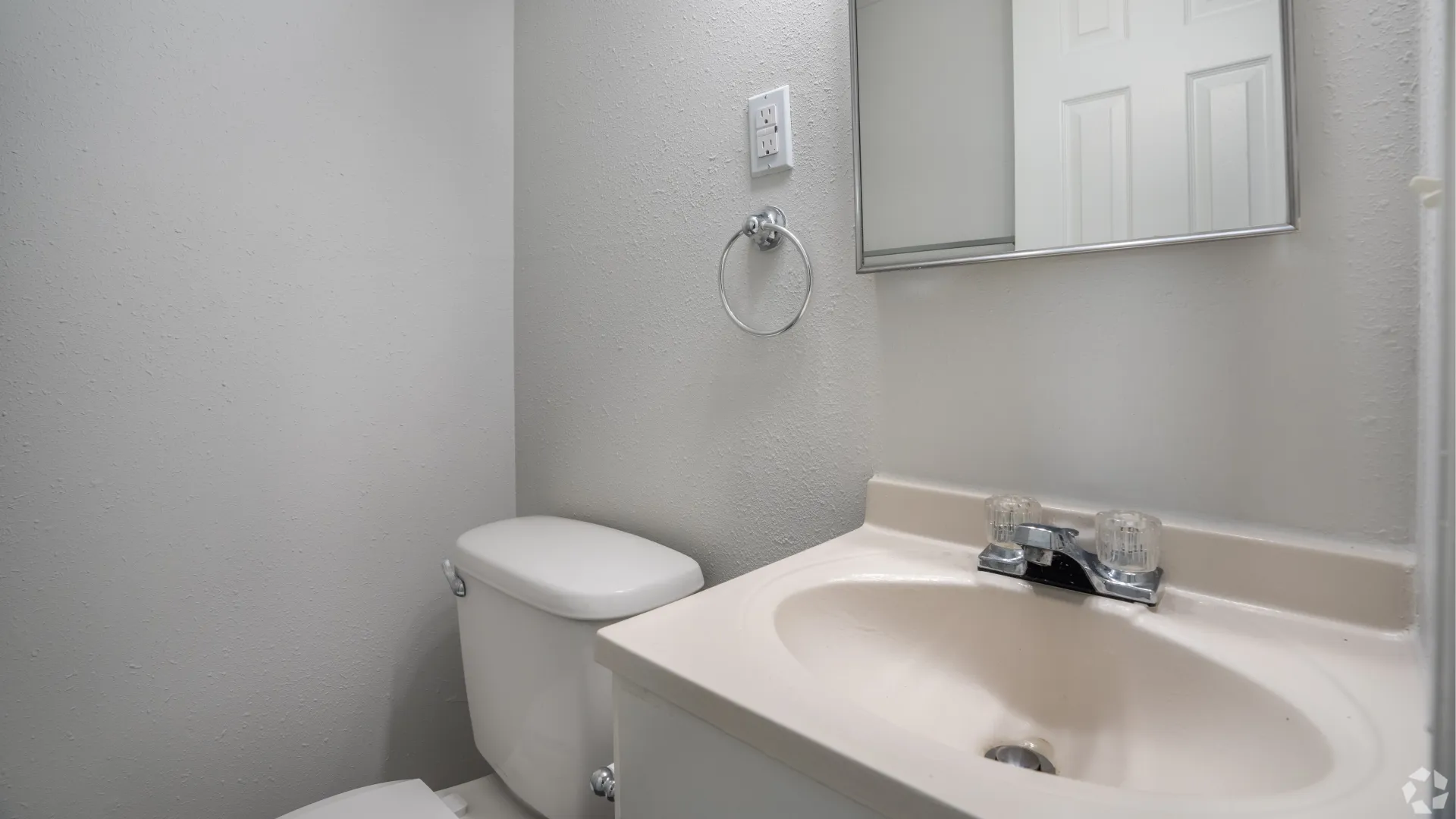 Half bath with a sink, mirror, and toilet in The Roswell floor plan.