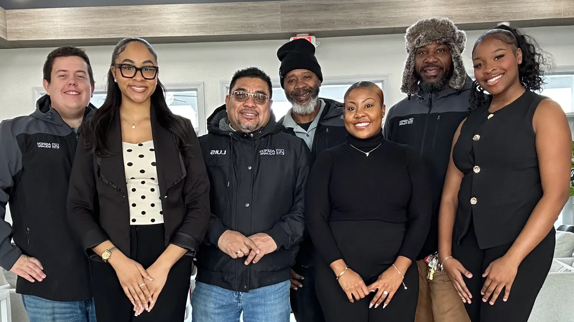 Group photo of the 100 South Apartments team in McDonough, featuring office and maintenance staff standing together in the leasing office.