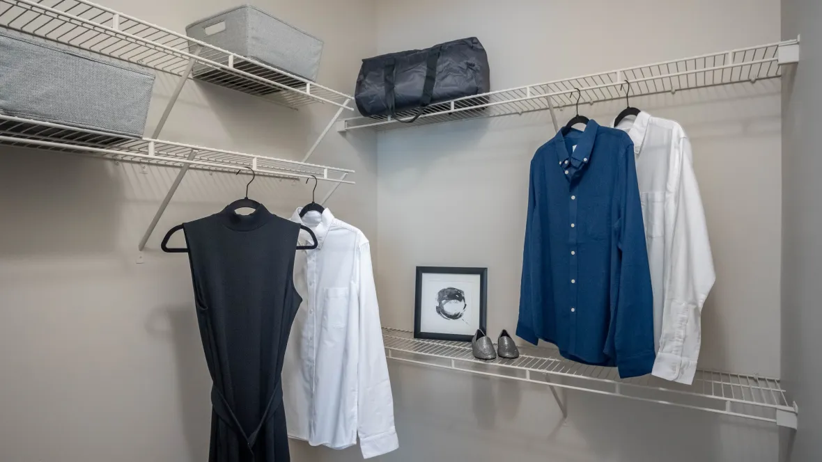 Spacious, walk-in closet with staggered shelving for organizing.
