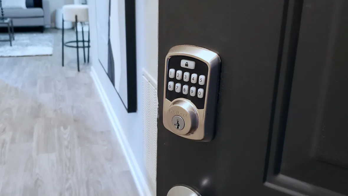 Kwikset brand Bluetooth smart lock on an apartment door, which allows keyless entry to the home.