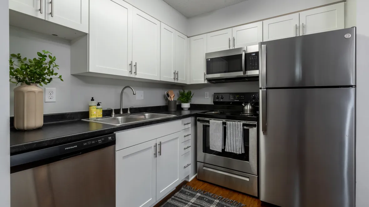 A contemporary kitchen with gleaming stainless-steel appliances, including a refrigerator, oven, and microwave over the stove. 