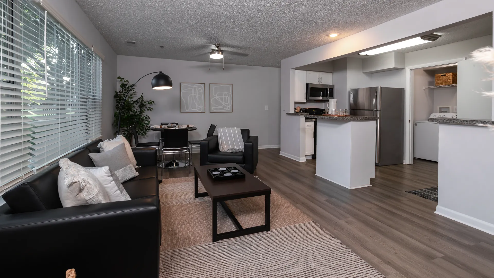 Modern open-concept living area at Onyx Apartments with sleek finishes, contemporary furnishings, and seamless flow from the living room to the kitchen.