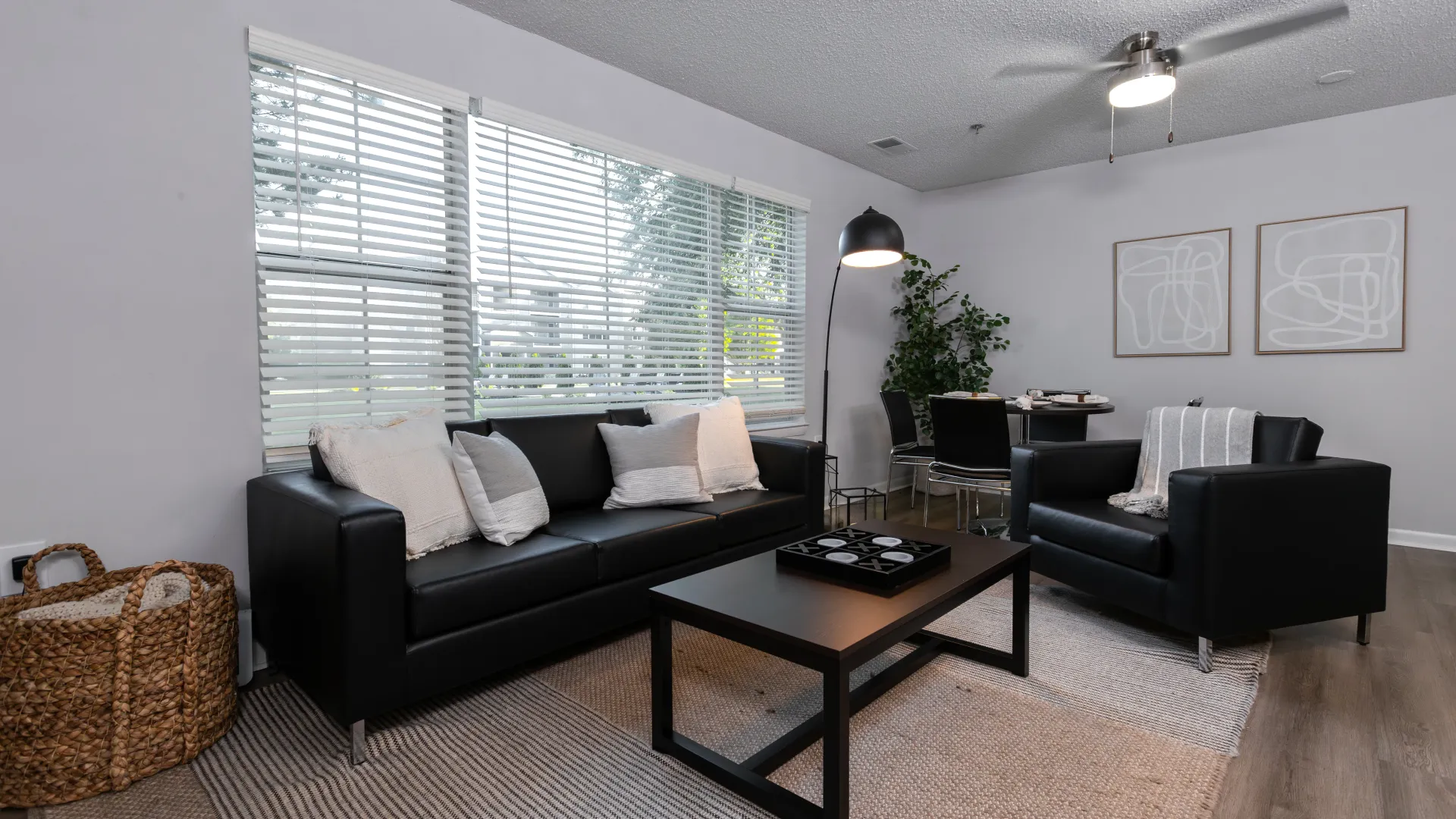 Cozy and stylish living room at Onyx Apartments featuring modern decor, ample natural light, and a comfortable seating arrangement with a sofa, armchair, and coffee table.