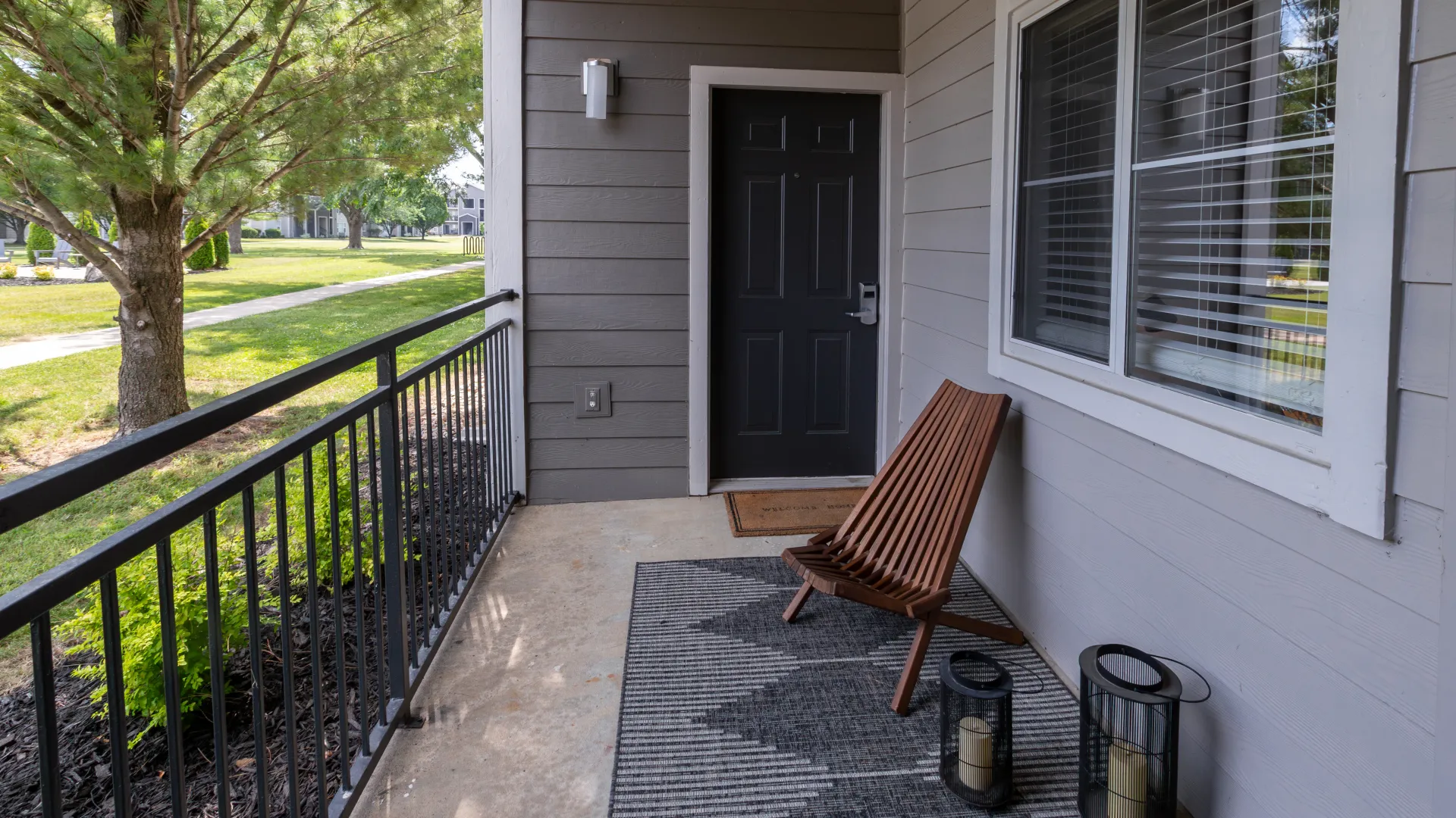 Private patio featuring a comfortable chair, decorative lanterns, and views of the lush green surroundings. Ideal for relaxation and enjoying the outdoors.