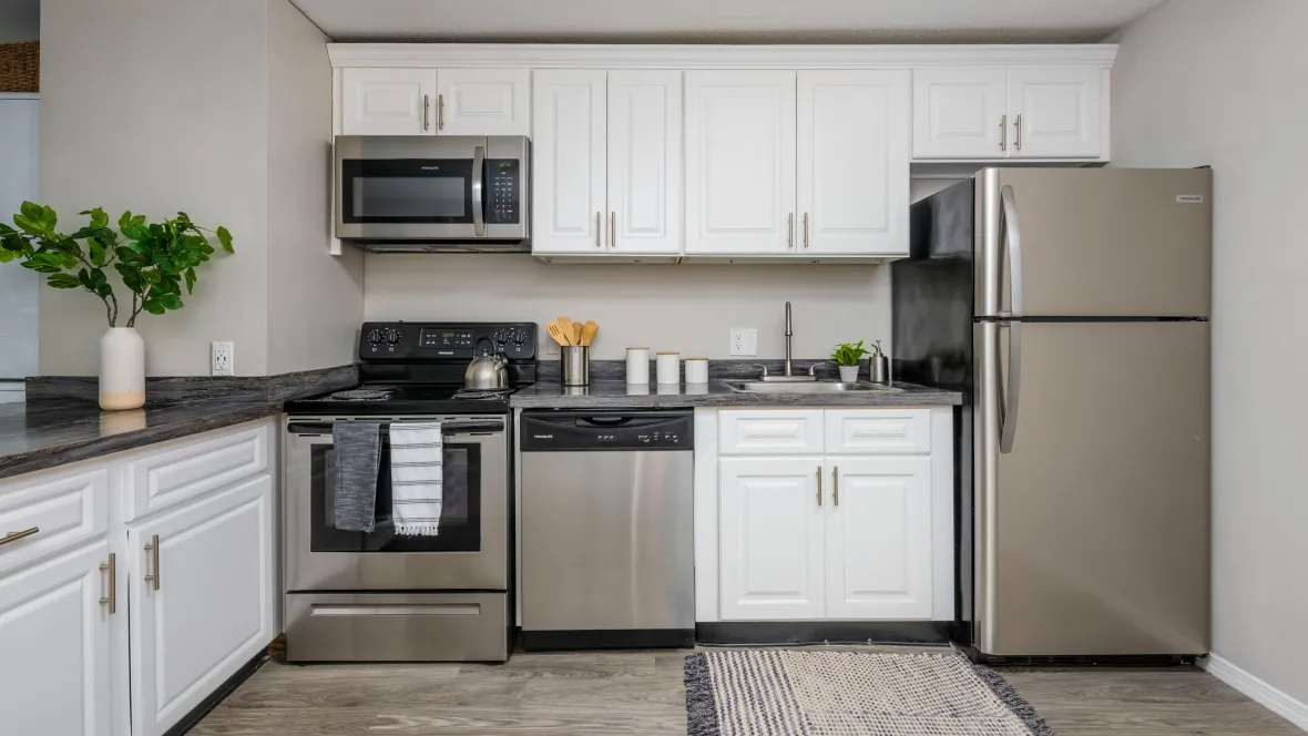 A kitchen equipped with stainless steel appliances including refrigerator, dishwasher, stove and microwave above the stove.