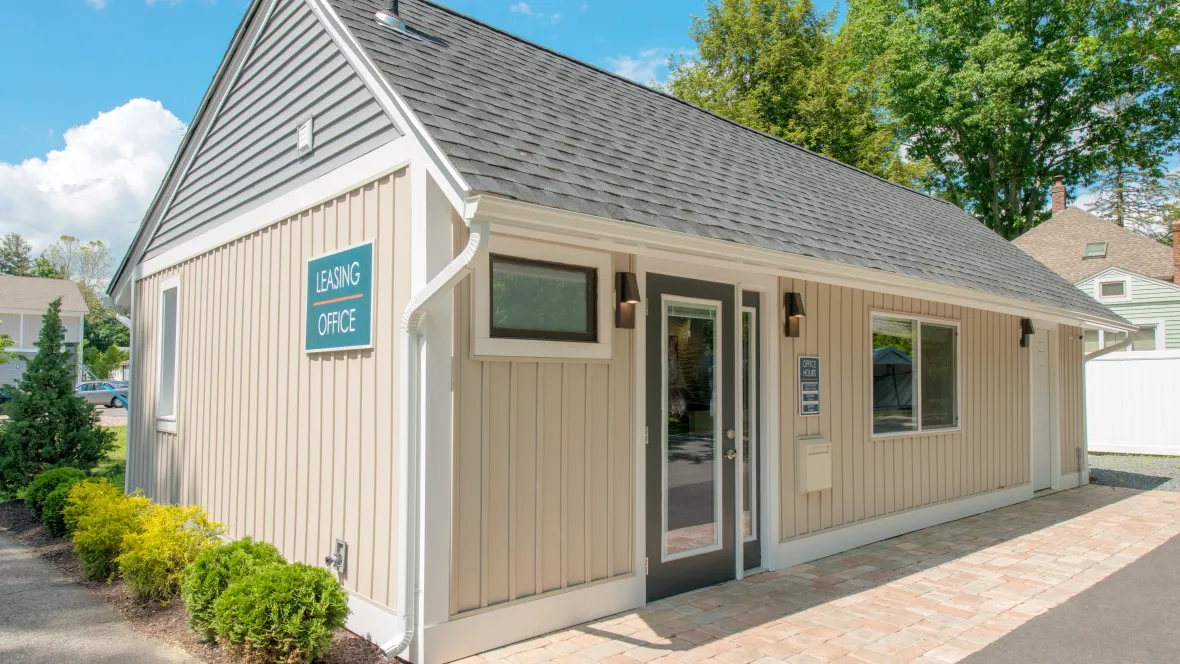 Exterior of the leasing office with signage showing “Leasing Office” as well as the posted office hours and a convenient letter drop box. 