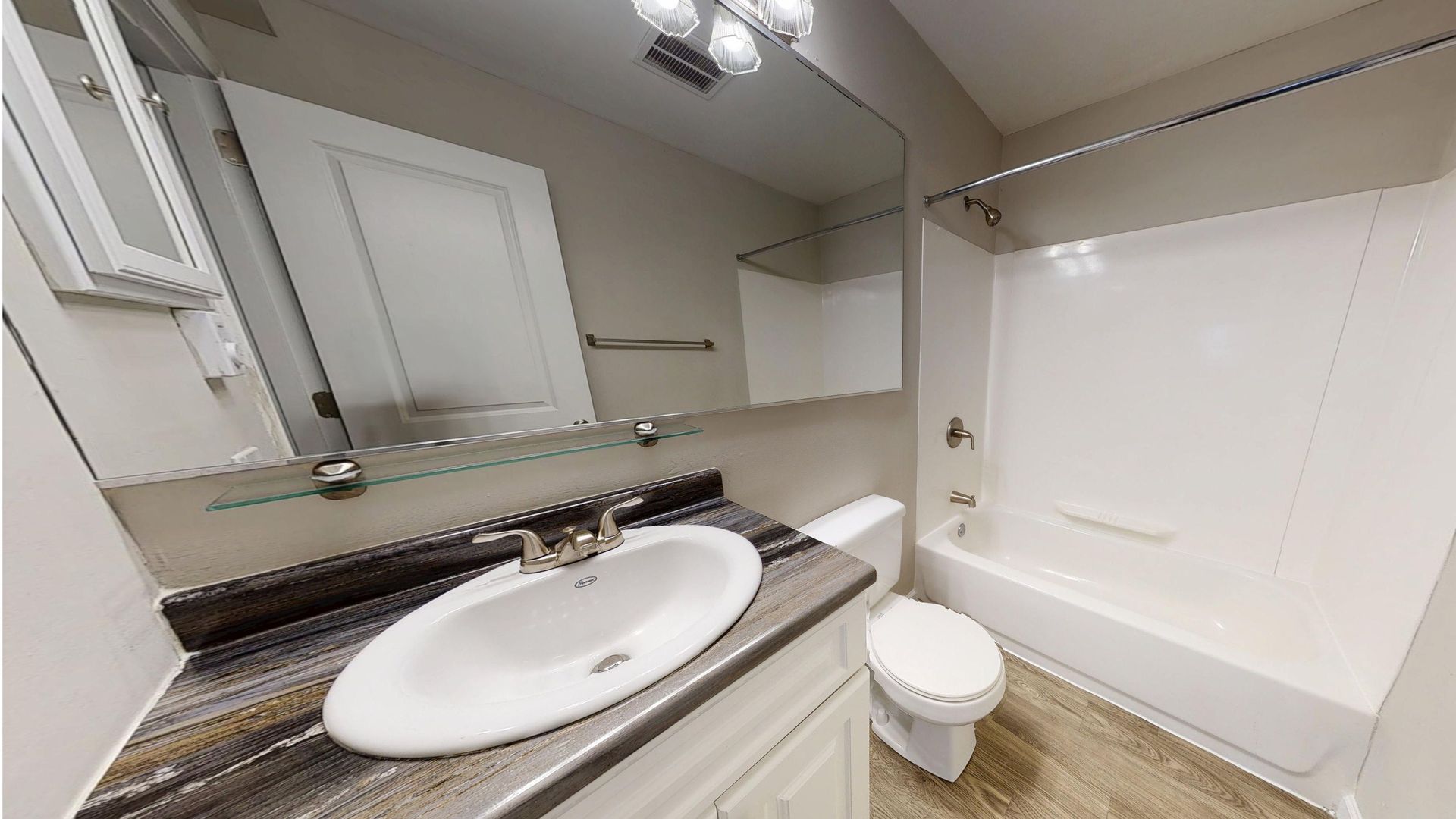 Full bathroom with vanity, mirror, and tub inside The Hampshire studio floor plan at Alpine Commons.