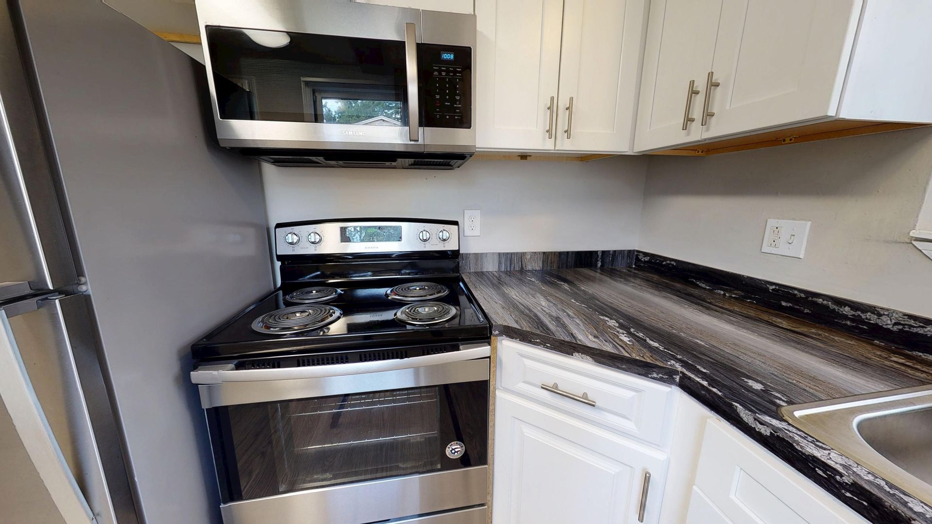 Kitchen in The Hampshire floor plan featuring stainless steel appliances and black-fusion countertops.