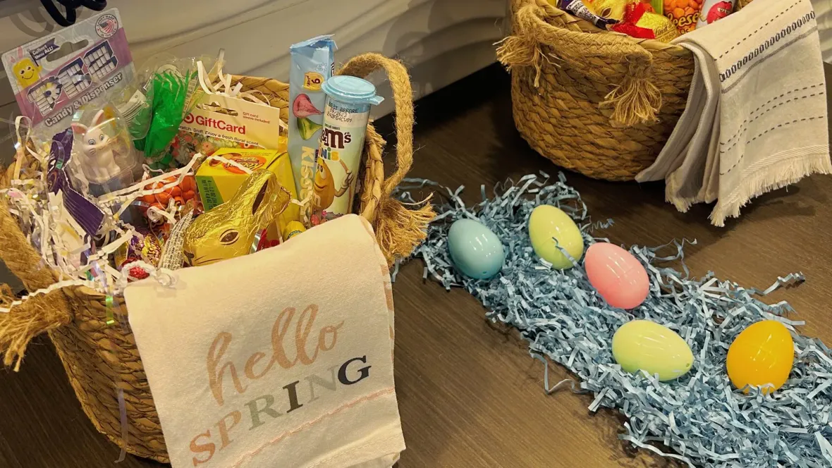 A close up photo of an easter basket raffle giveaway with Easter grass and eggs next to it for decoration.