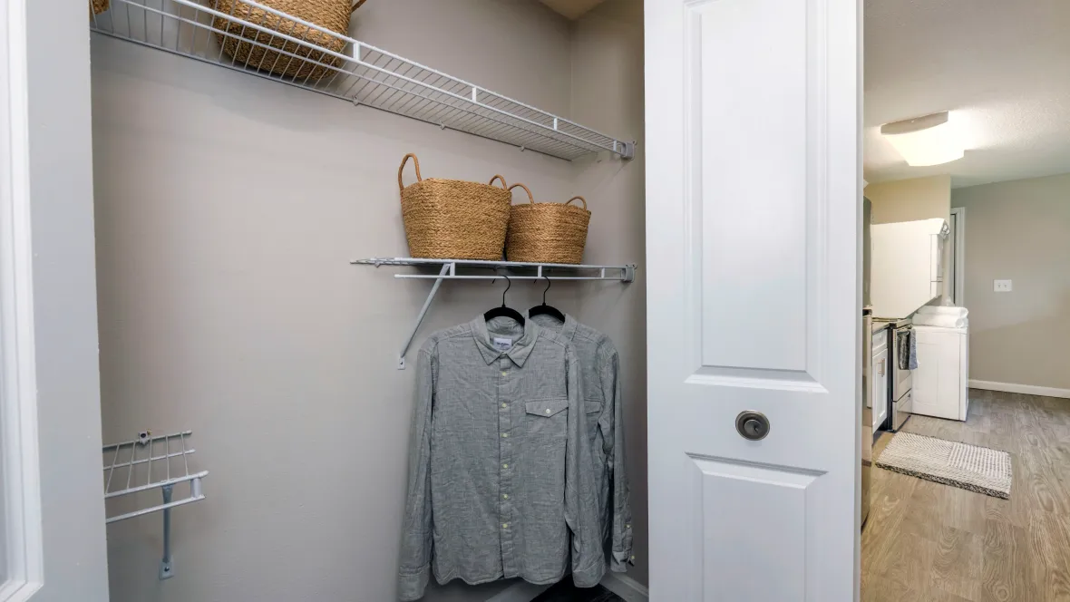 A spacious closet with double doors and abundant built-in open wire organizers.