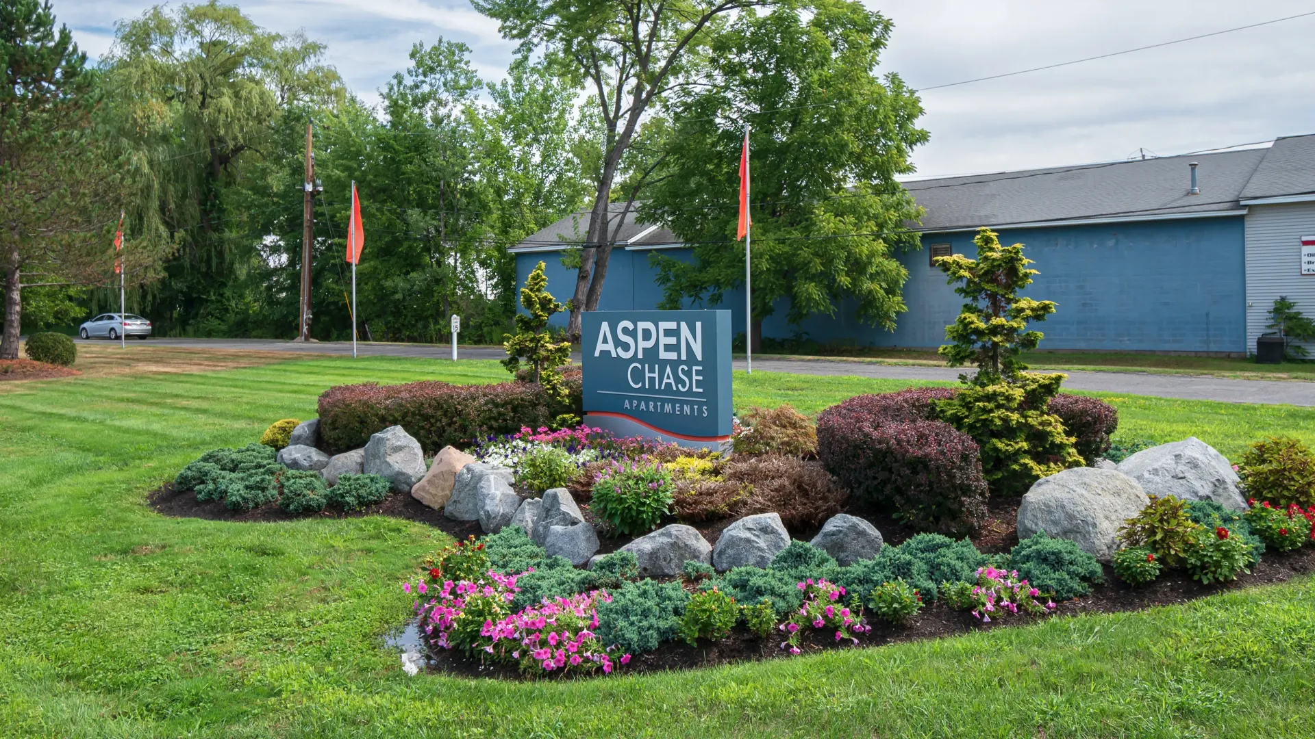 Monument signage for Aspen Chase Apartments with lush landscaping surrounding creating a welcoming atmosphere. 