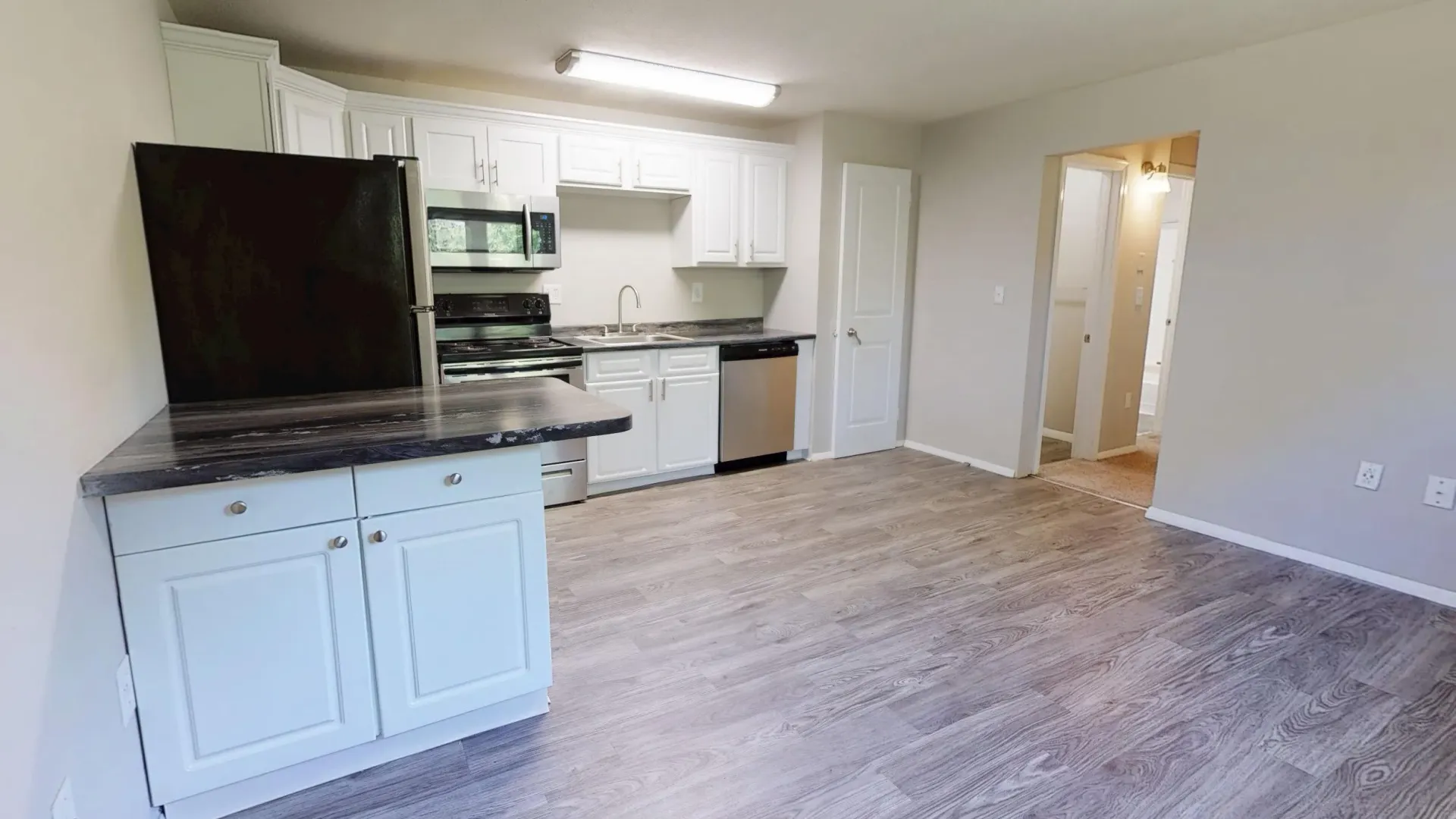 Spacious open floor plan with wood-style flooring and updated fixtures at Aspen Chase.