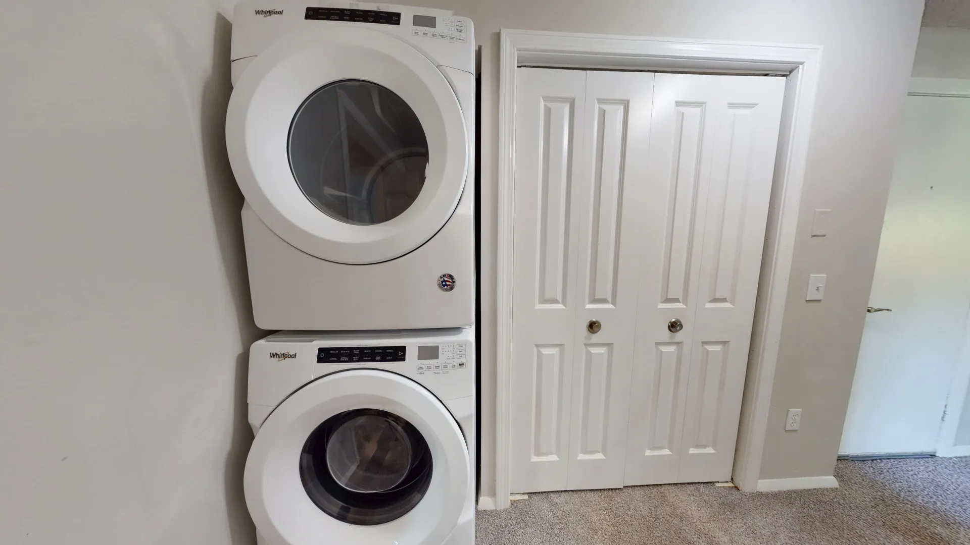 Laundry setup with white Whirlpool appliances in a hallway of The Alma Mater floor plan.