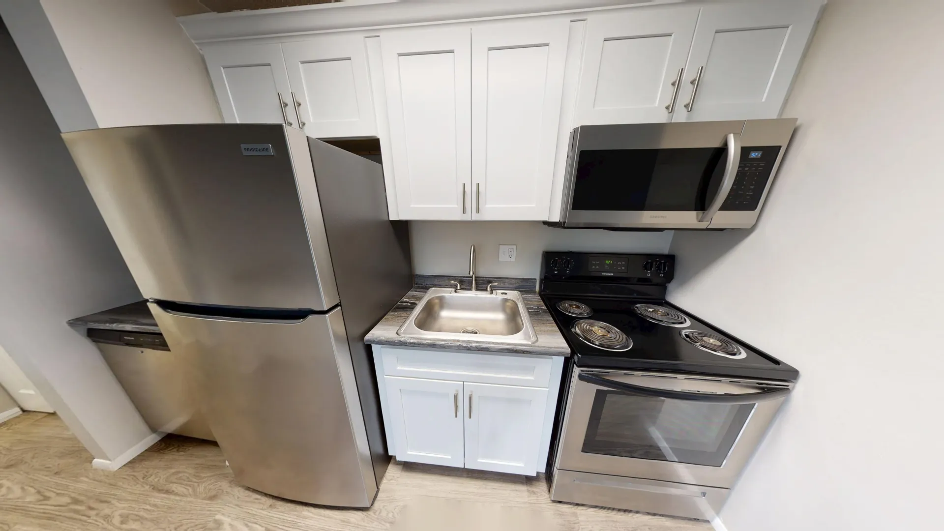 Stainless steel kitchen appliances and white cabinetry in The Dickenson floor plan at Aspen Chase Apartments.
