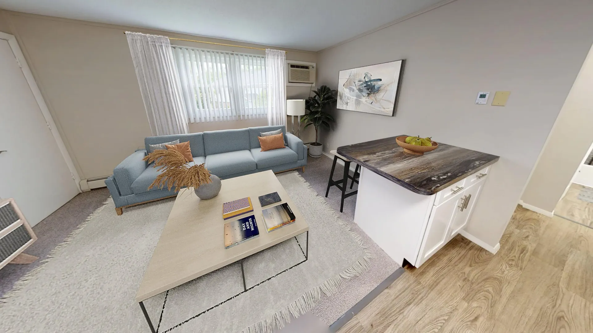 Spacious living room in The Dickenson floor plan at Aspen Chase Apartments featuring modern furnishings and breakfast bar with updated countertops.