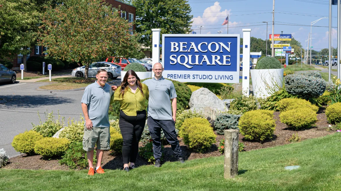 A photo of the Beacon Square team in front of the front sign.