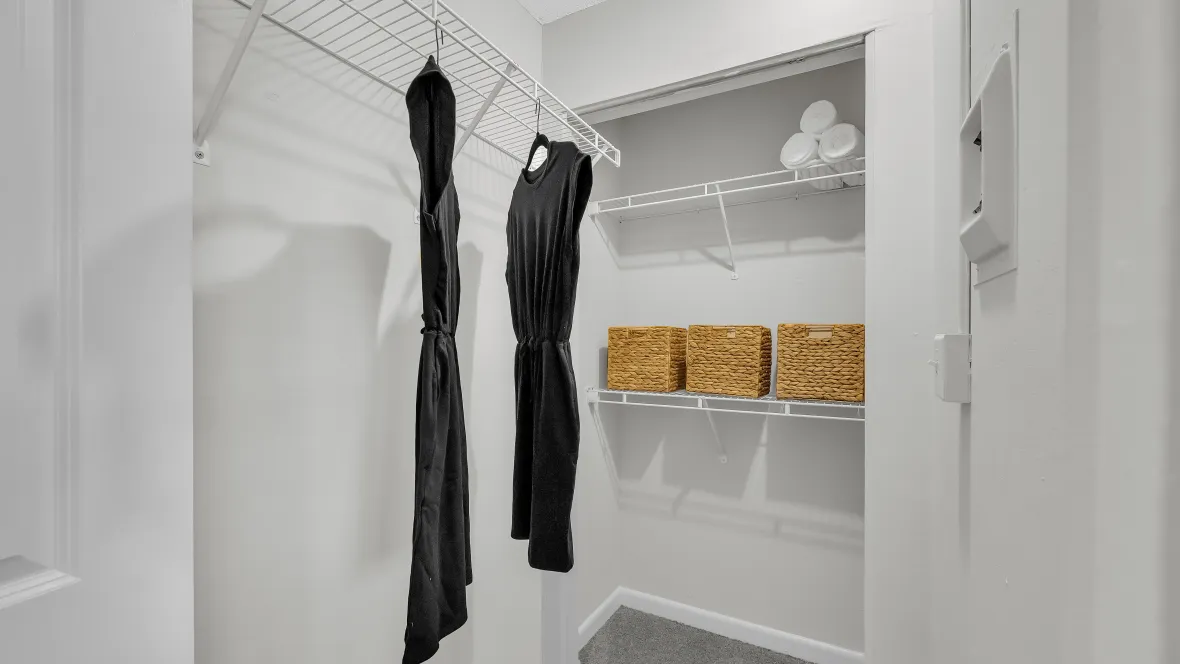 A well-organized walk-in closet with shelving.