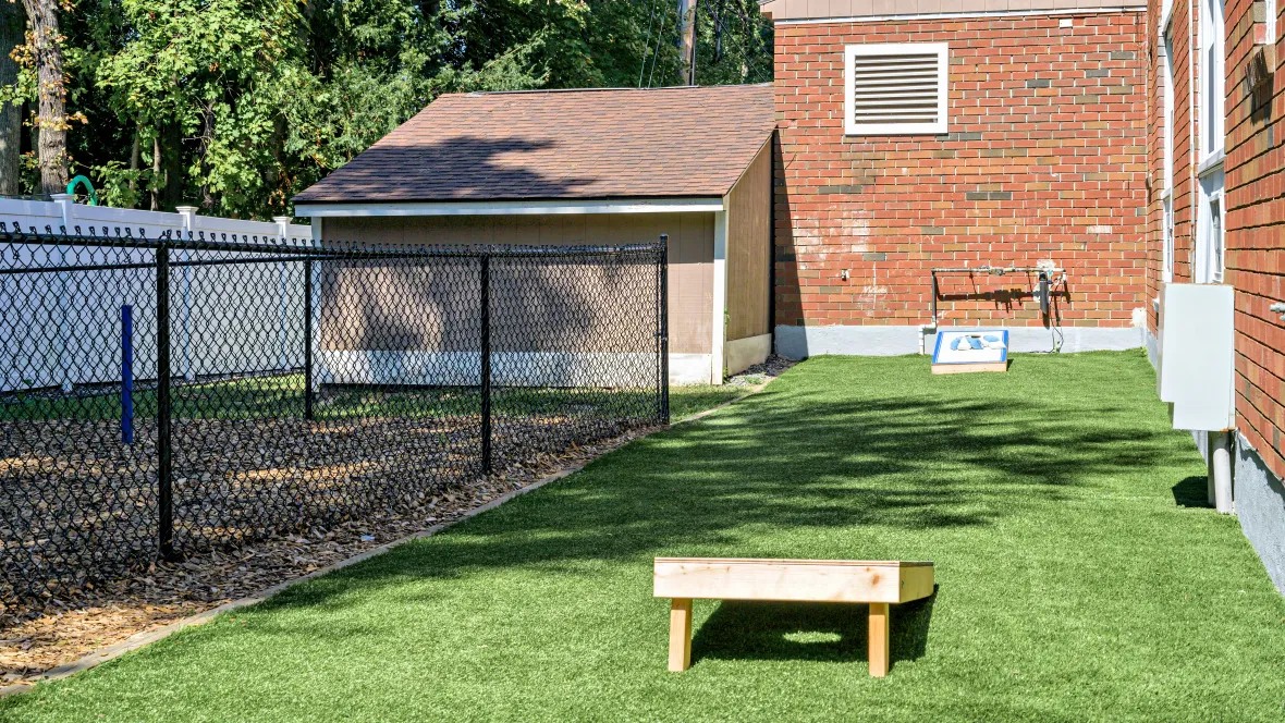 A set of two cornhole boards on a section green grass.