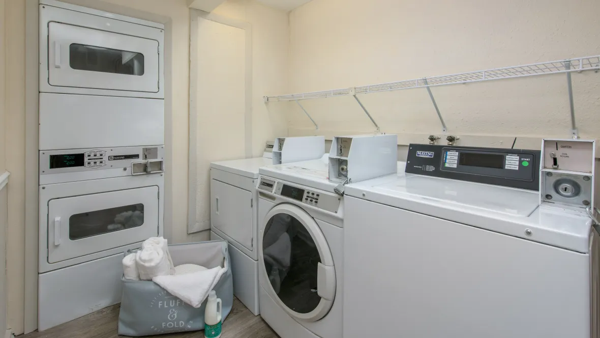 Spacious community laundry room equipped with multiple washers and dryers for residents' convenience.