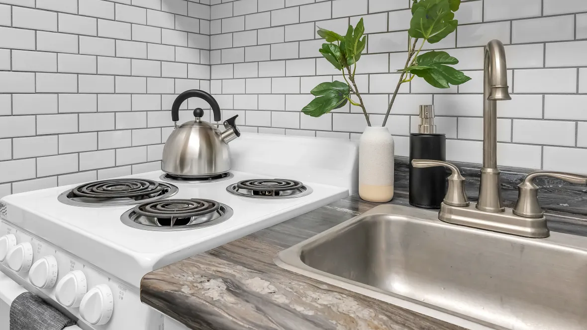 Close-up view of the white subway tile backsplash behind the kitchen sink and stove.