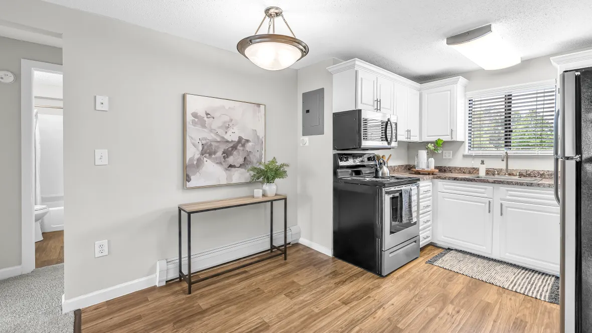 An elegant dining area with wood-like floors and a stylish overhead lighting feature, setting the ambiance for delightful meals.