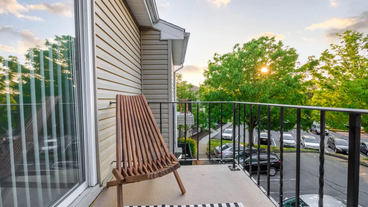 A blissful view of the sunset from a spacious patio with inviting furnishings and an intricate wrought iron railing.