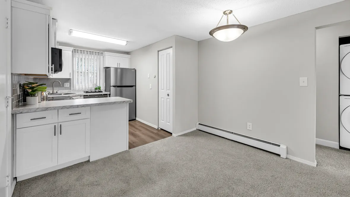 A delightful, carpeted dining area offering convenience to the kitchen and living room in an airy, open floorplan. 