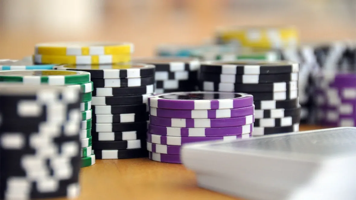 A close-up view of poker chips and playing cards on a table