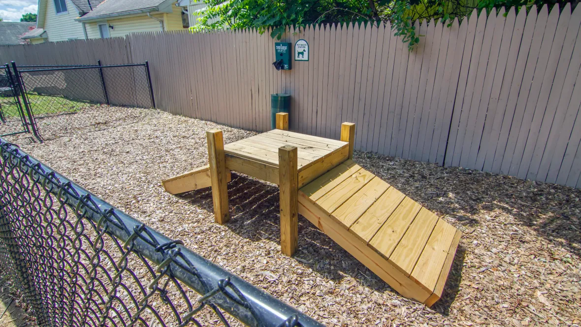 A fenced-in dog park with dog ramp for agility and fun. 