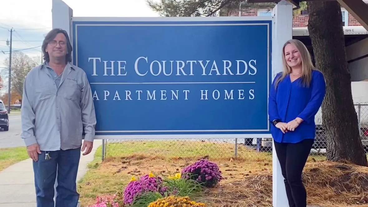 The Courtyards team poses for a photo in front of their front sign.