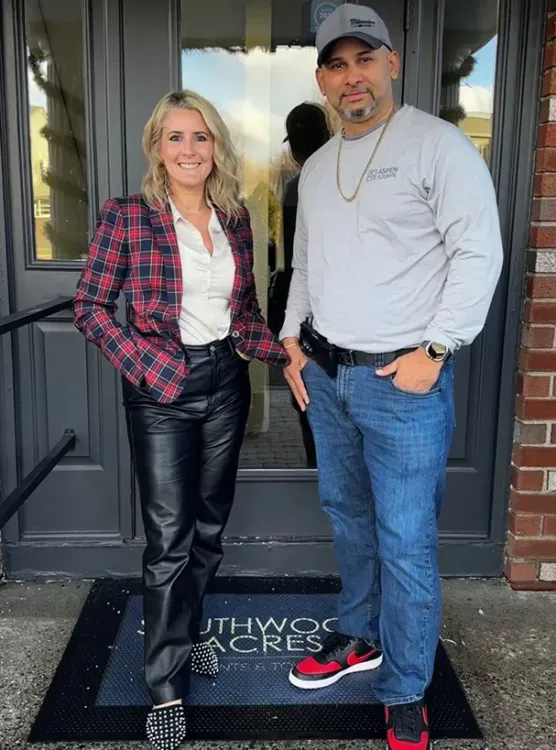 Two team members from Southwood Acres Apartments posing outside the entrance, showcasing their commitment to community and service.