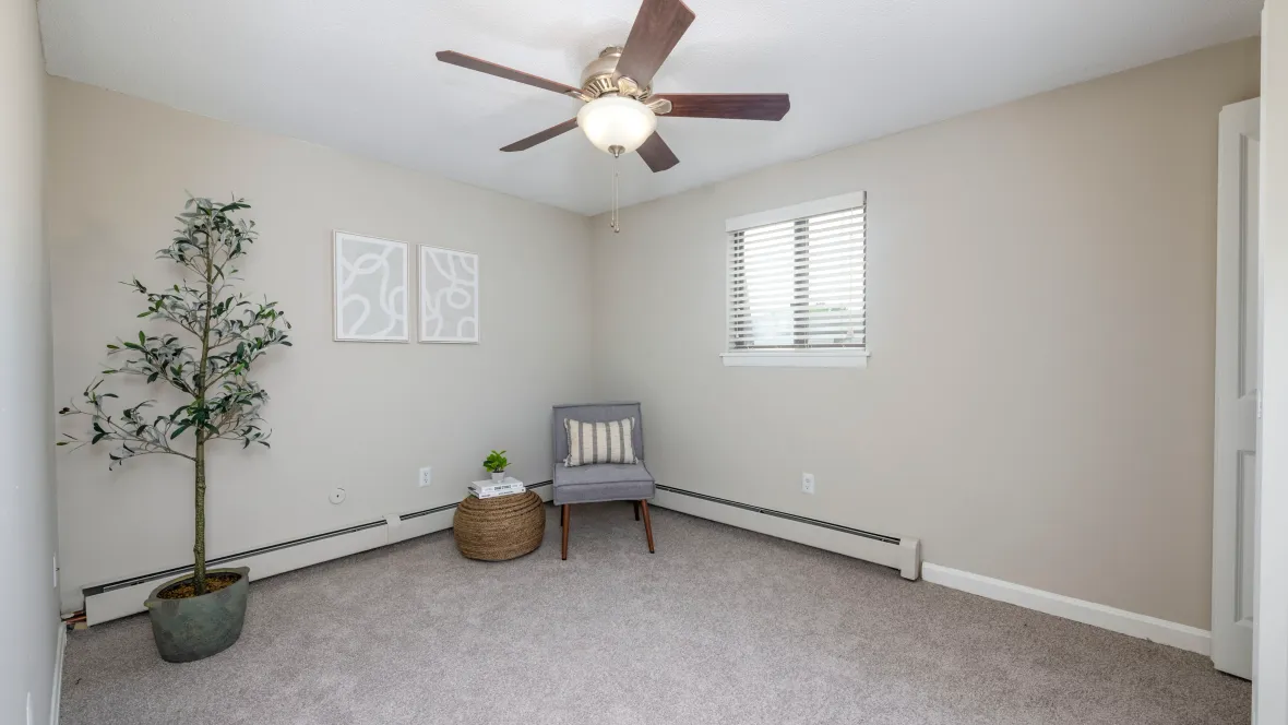 Restful bedroom ambiance with a multi-speed ceiling fan, carpeted flooring, and baseboard heaters for the ultimate enjoyment.