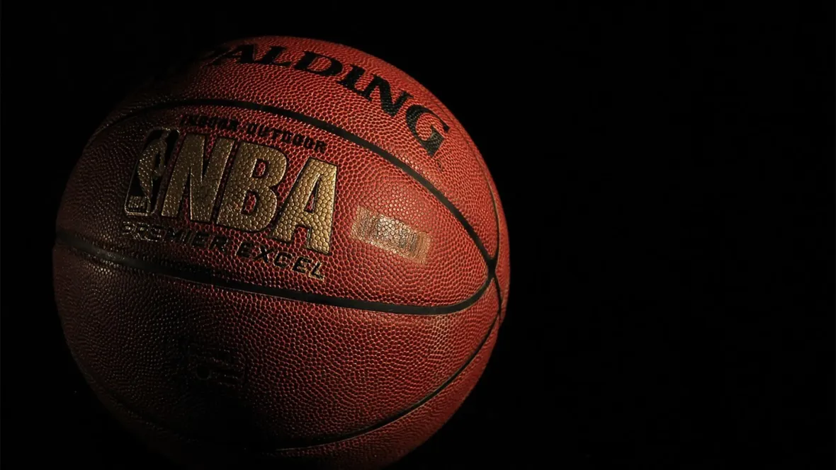 A close-up of a basketball branding the NBA logo