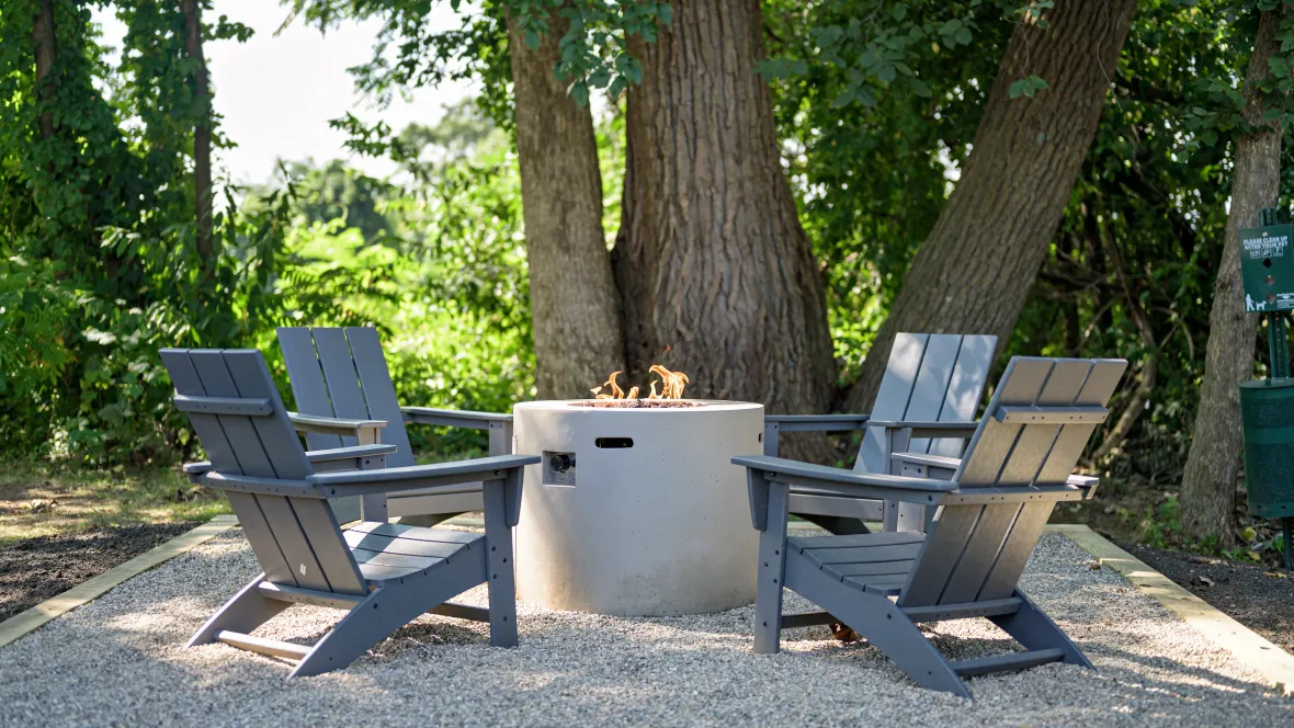 A roaring flame at the firepit surrounded by Adirondack seating.