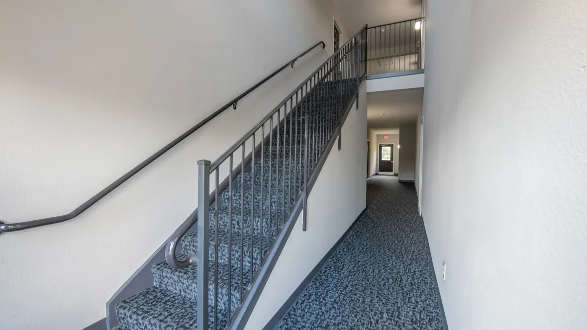 Clean, modern carpeted interior breezeway leading to your apartment, sheltered from the elements.