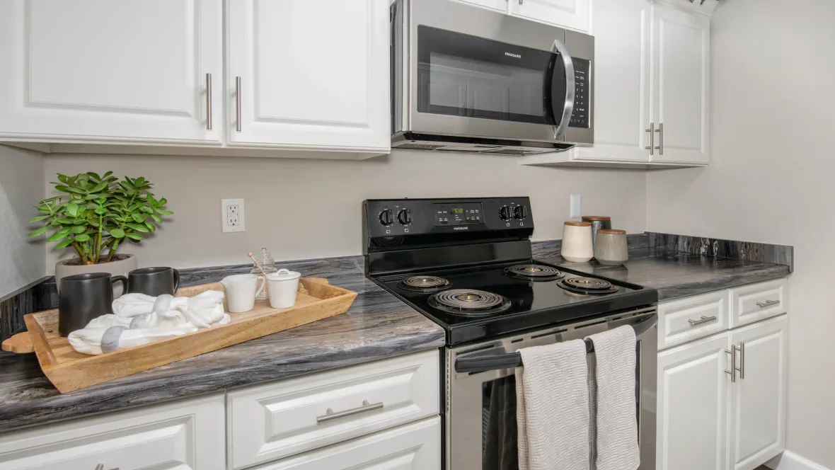 Galley kitchen with stainless steel stove and microwave, ready for gourmet cooking and delightful meals.