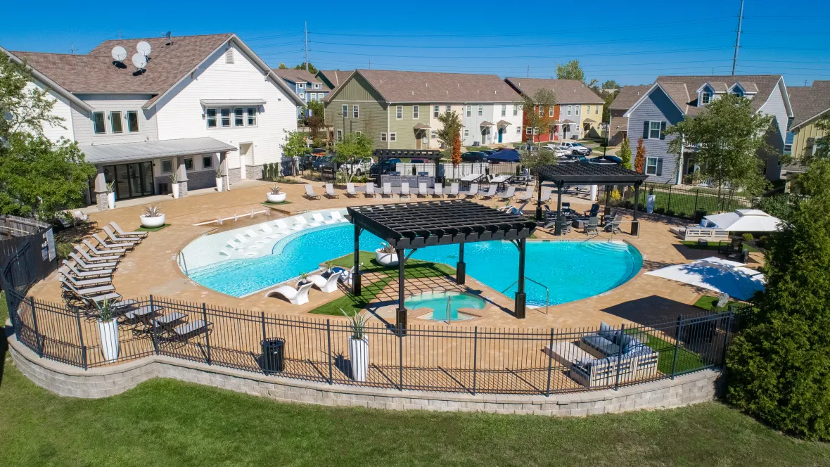An aerial view of an expansive sundeck and pool with multiple lounging options.