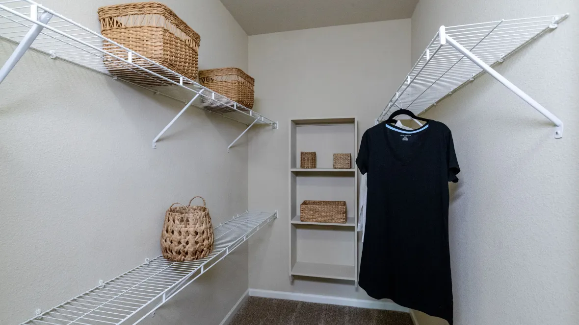 A spacious closet with built-in storage and multiple levels of hanging space to maximize storage.