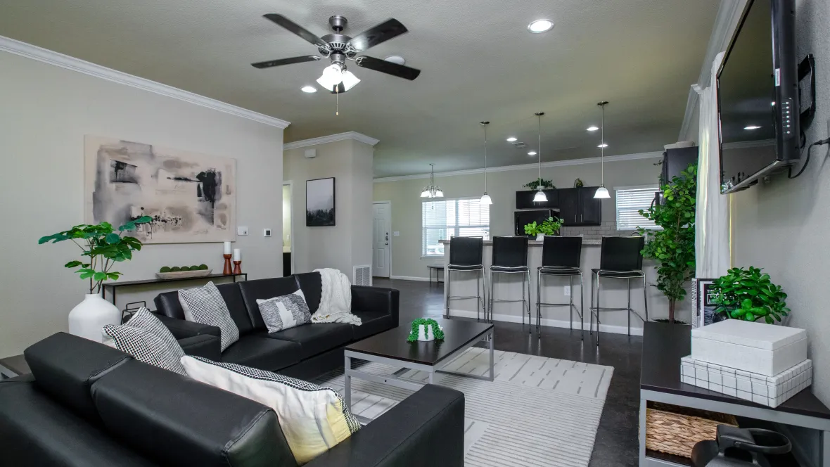 An expansive living room fully furnished with sofa, love seat, coffee table, and television.