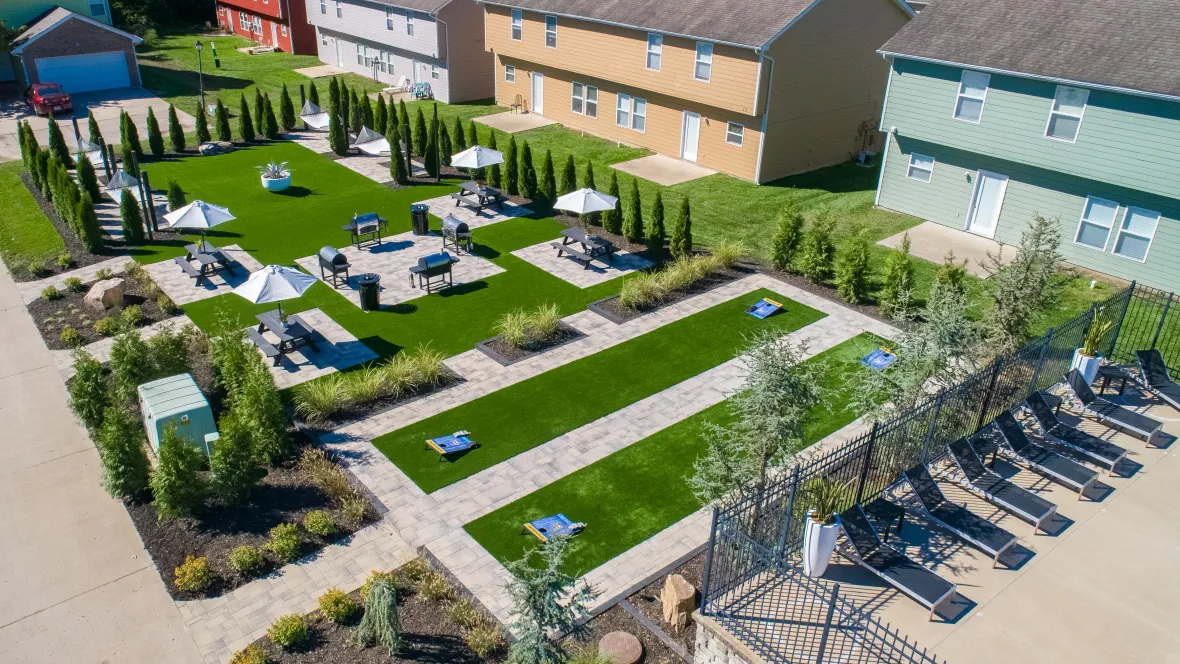 An overhead perspective of our diverse outdoor amenities found in the courtyard of our vibrant college community including cornhole nestled between the pool and picnic tables and hammocks near the BBQ grills. 