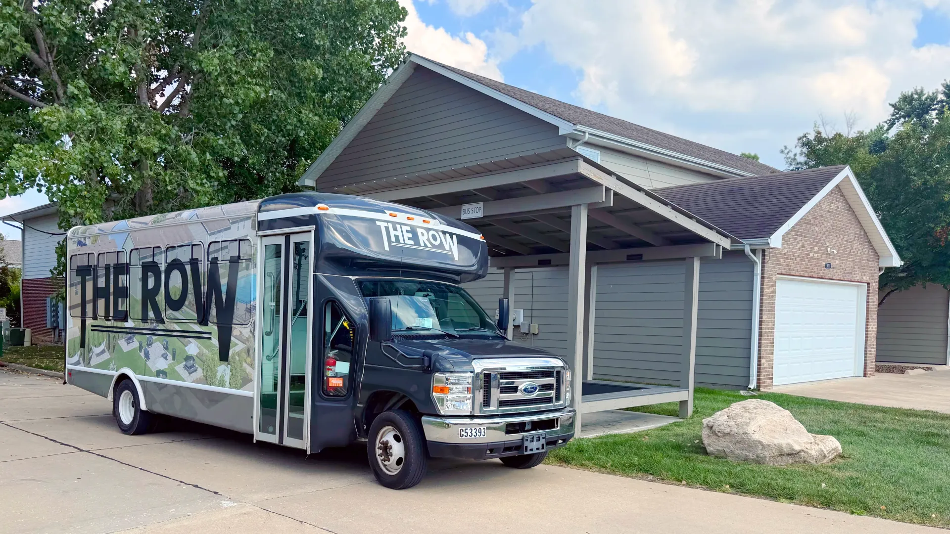 The Row Apartments shuttle bus parked at the on-site covered bus stop in Columbia, MO.