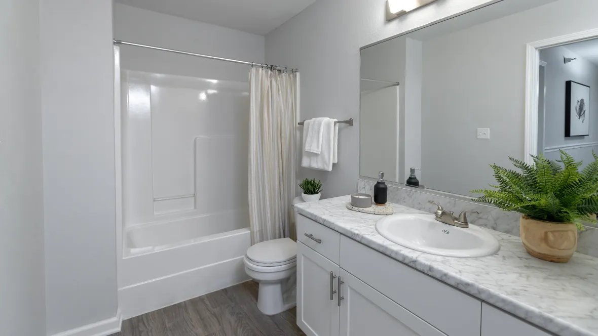 A stylish restroom graced with deluxe White Carrera countertops and grand mirrors.
