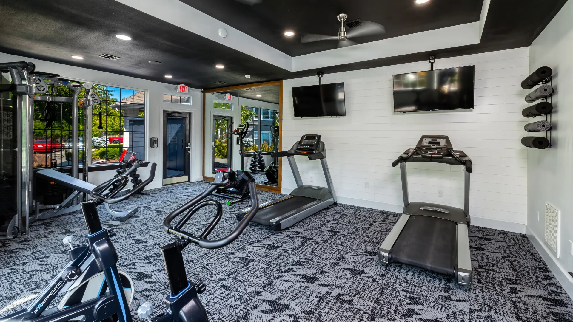 A dynamic view of the fitness center showcasing treadmills, spinning bikes, weight training, and free weights, offering an unmatched resident gym experience.