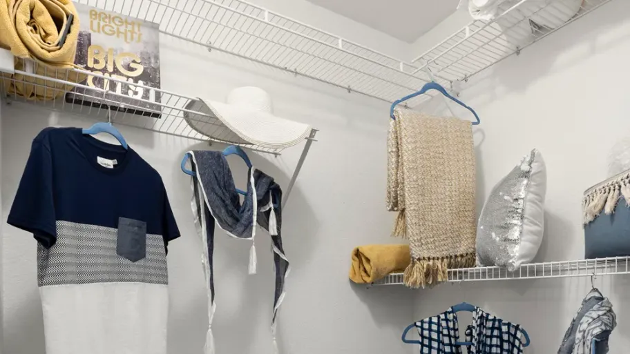 A large walk-in closet featuring wall-to-wall customized shelving for organized storage.