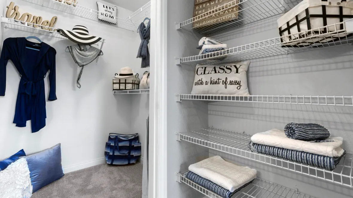 An enormous walk-in closet with customized open wire shelving allowing for versatile storage open as well as an adjoining linen closet with five rows of shelving for even more space.