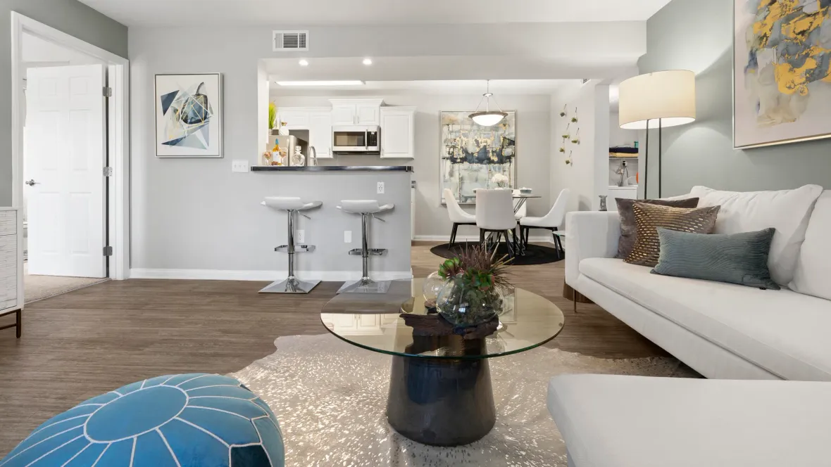 A seamlessly connected living space with open access between the kitchen, dining, and living areas for a seamless flow filled with comfortable, plush seating arrangements.  