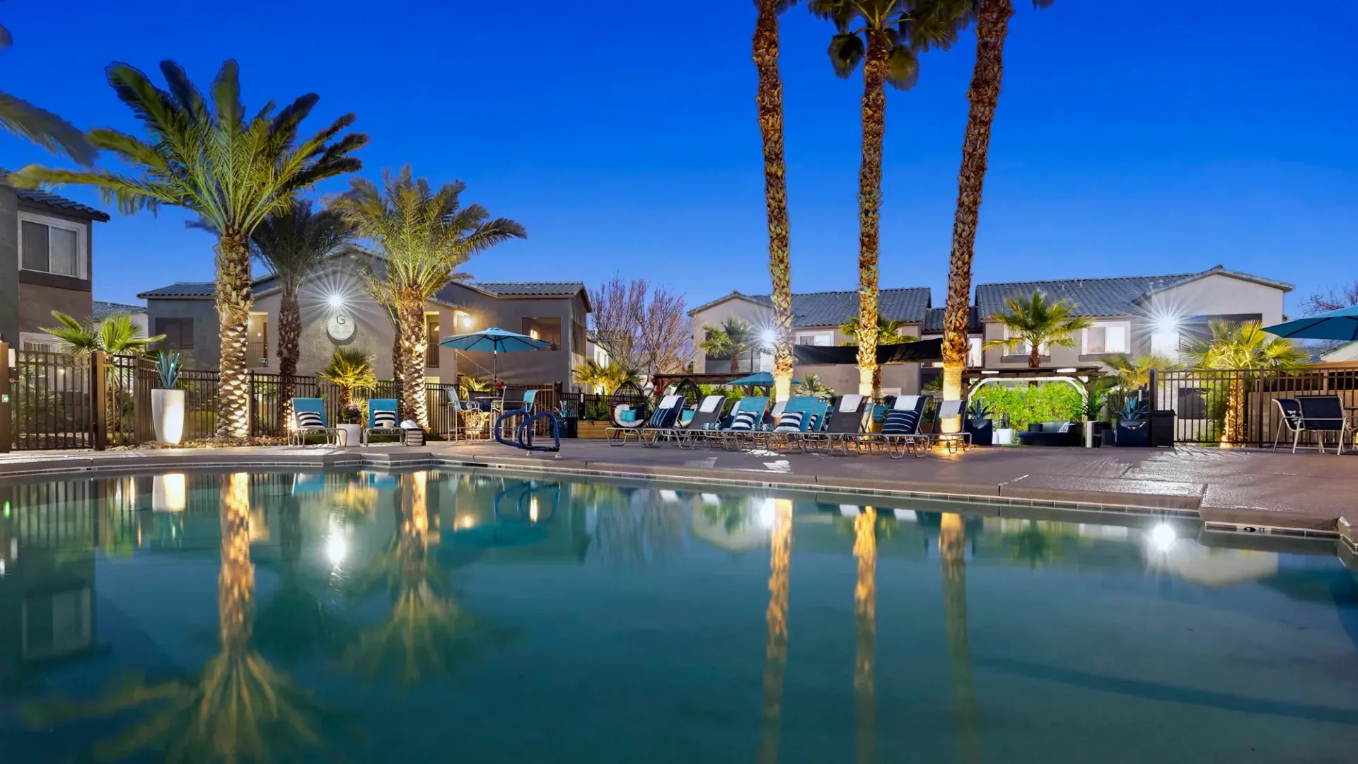 Reflections of the majestic palm trees and lights from the community reflect off the pool’s still waters at night for a calming space to unwind.