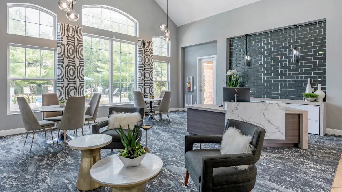 A freshly transformed leasing office with tall windows and modern lighting with ample seating options, creating a welcoming and cozy atmosphere.