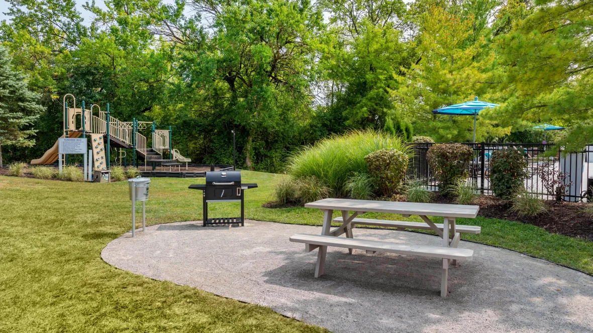 A picnic table and charcoal grill thoughtfully placed near the children's playground and just a stone's throw from the gated pool.