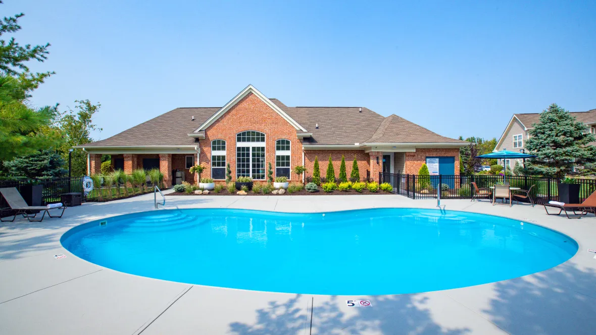 The poolside sanctuary, surrounded by meticulous landscaping and a charming red-brick clubhouse.